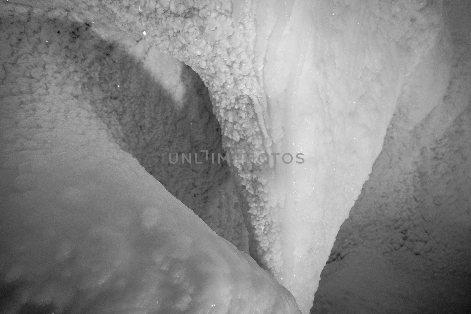 A fabulous artificial ice cave, the walls are covered with snow and illuminated. Frozen ice and cold inside