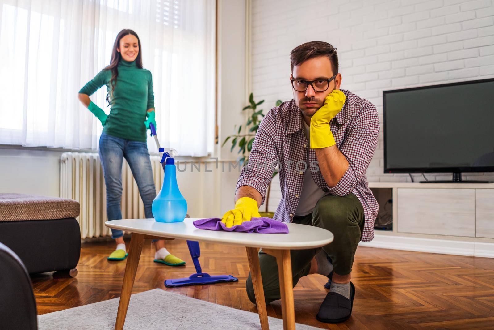Man is tired of cleaning the apartment. Woman is angry.