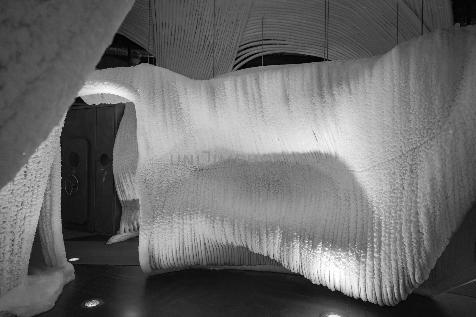 A fabulous artificial ice cave, the walls are covered with snow and illuminated. Frozen ice and cold inside