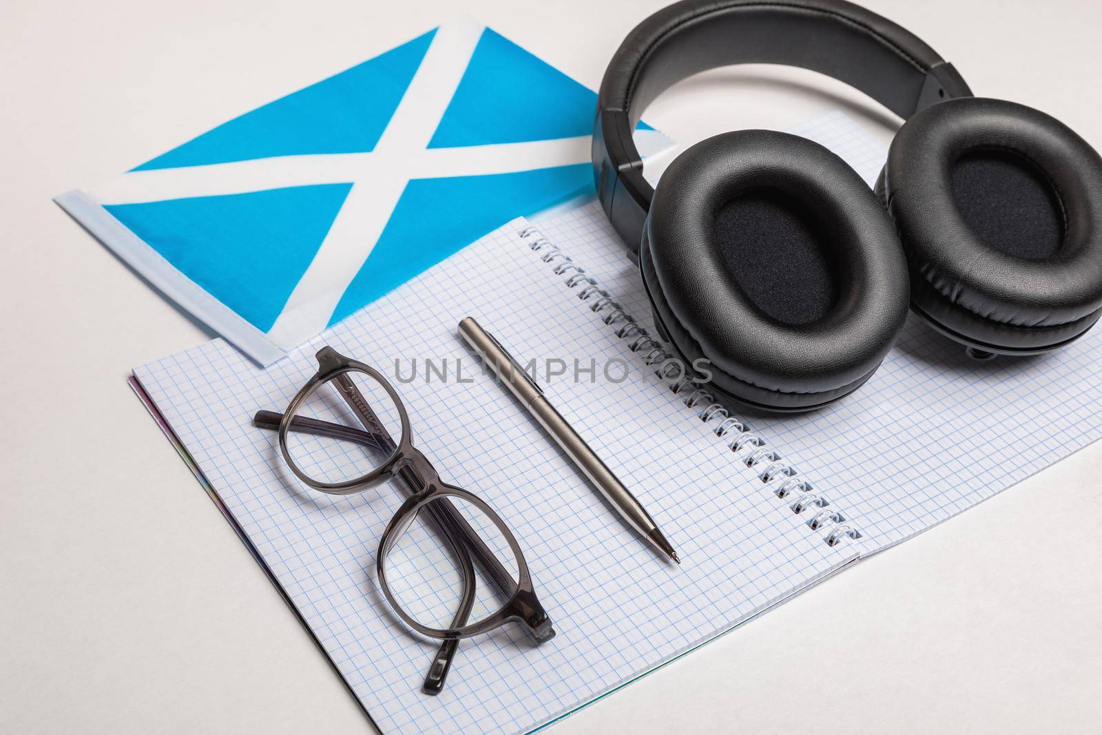 Learning foreign languages in Scotland with audio recordings and headphones. Notepad, glasses, pen.