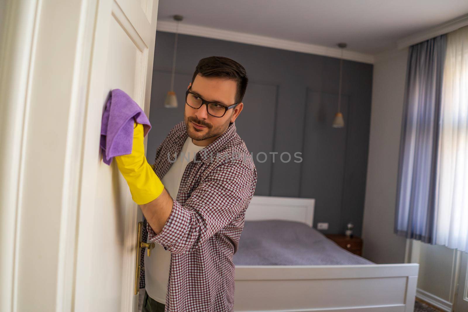 Young man is obsessively cleaning the apartment.