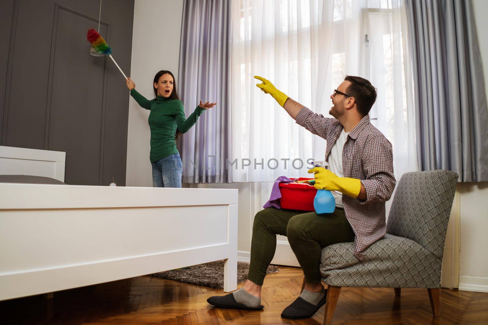 Woman is angry because her husband is lazy and avoids cleaning apartment.