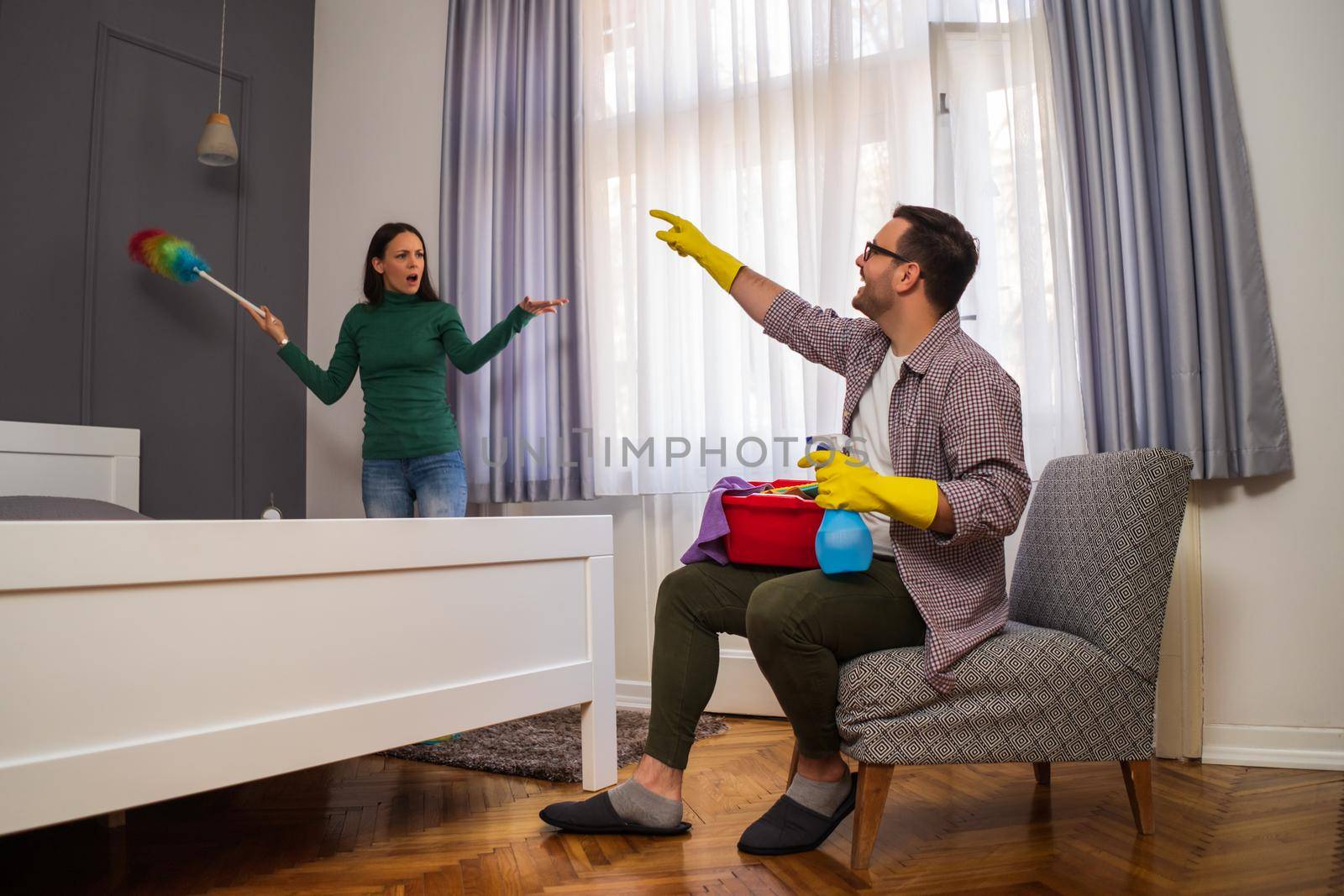 Woman is angry because her husband is lazy and avoids cleaning apartment.