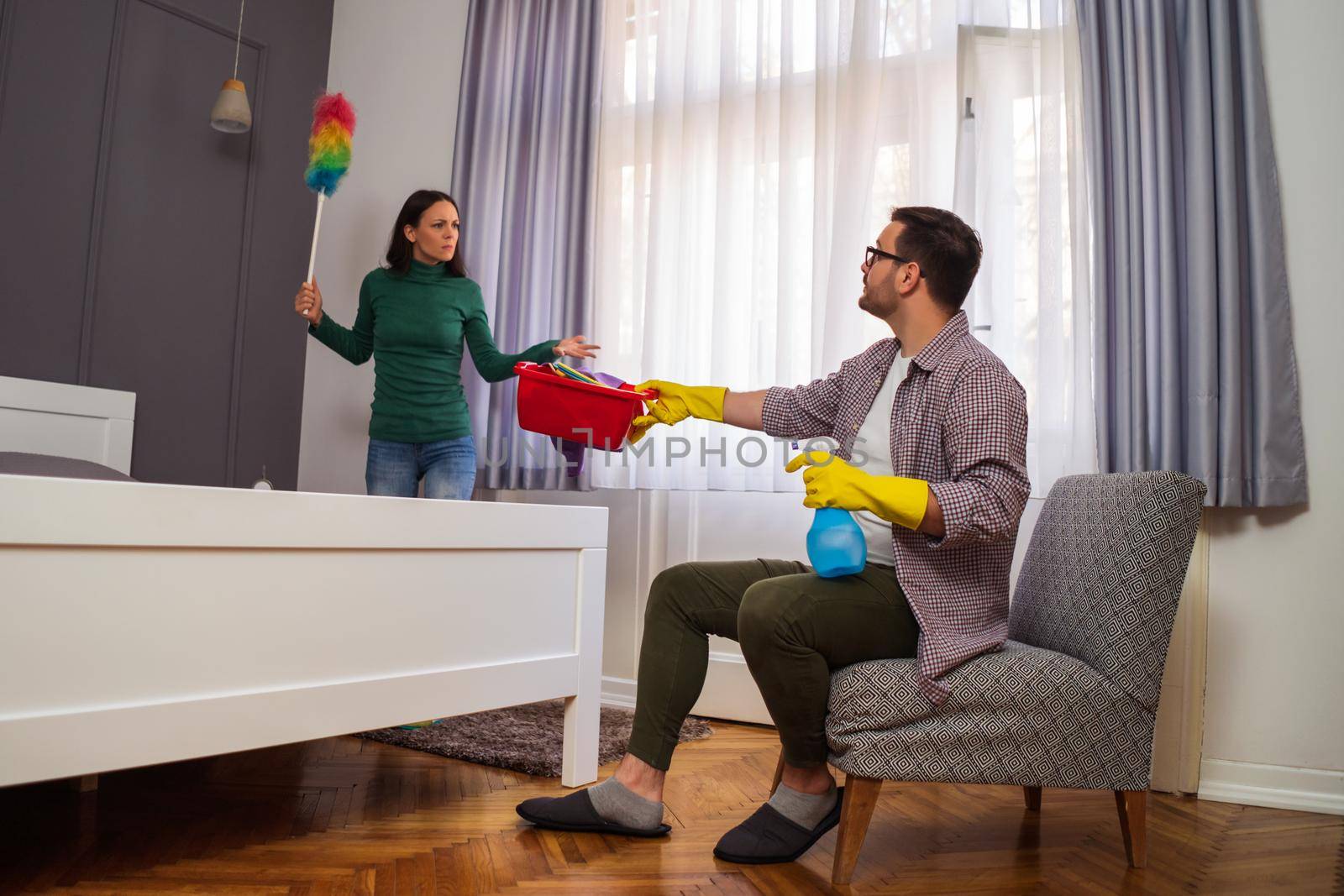 Woman is angry because her husband is lazy and avoids cleaning apartment.