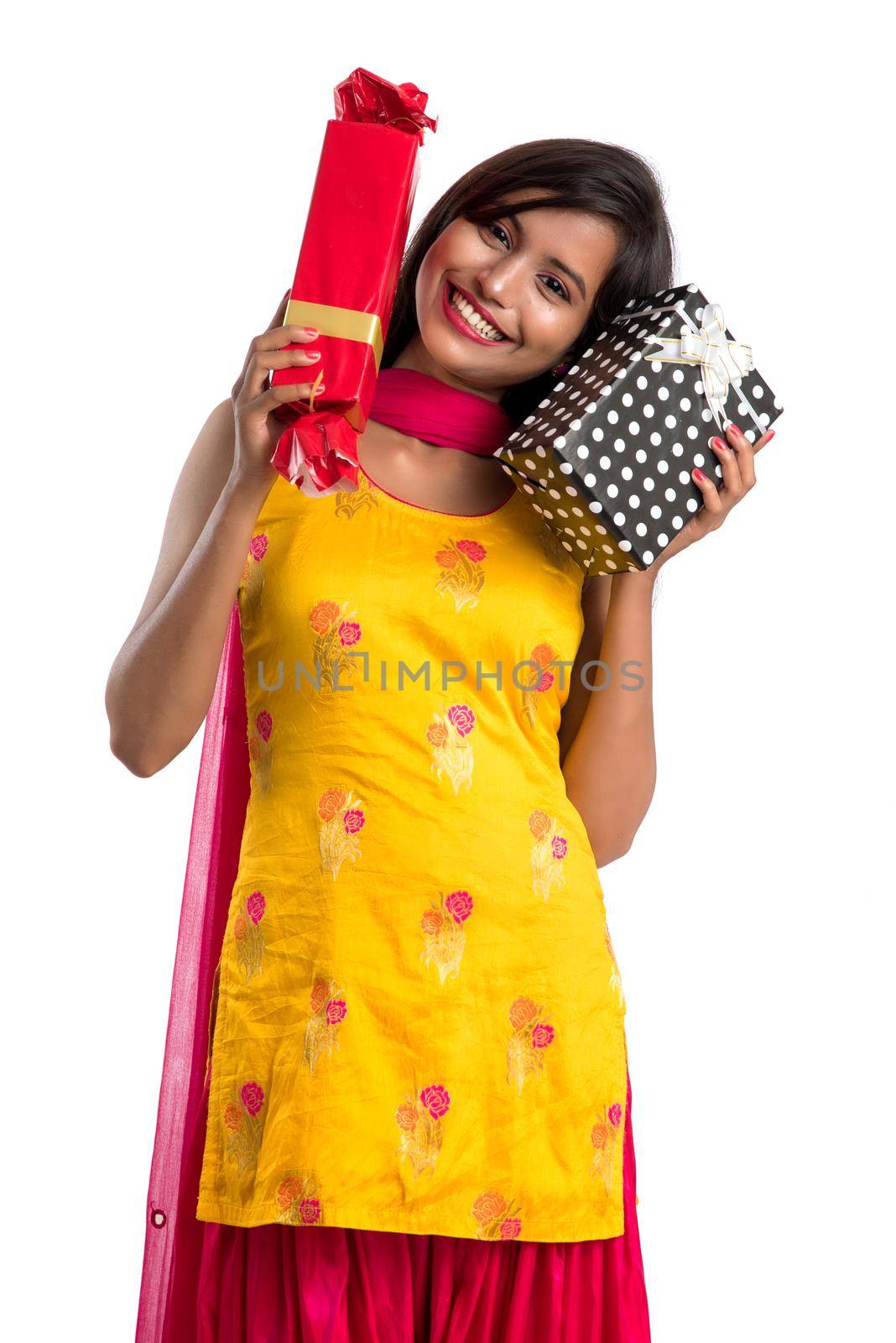 Portrait of young happy smiling Indian Girl holding gift boxes on a white background. by DipakShelare