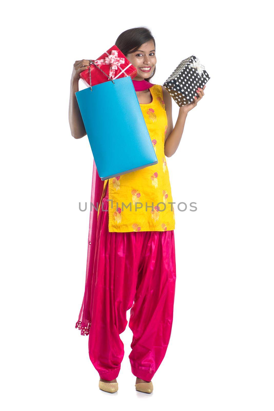 A beautiful woman posing with a shopping bag and gift Boxes on a white background.