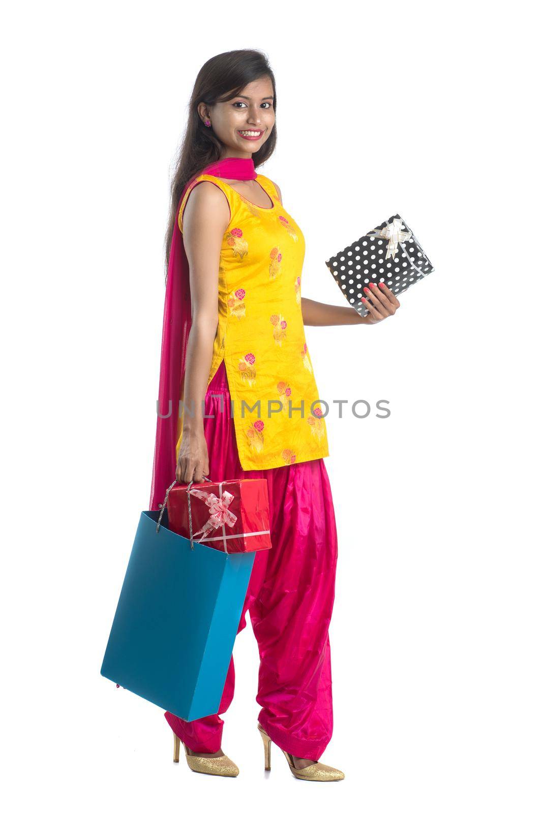 A beautiful woman posing with a shopping bag and gift Boxes on a white background.