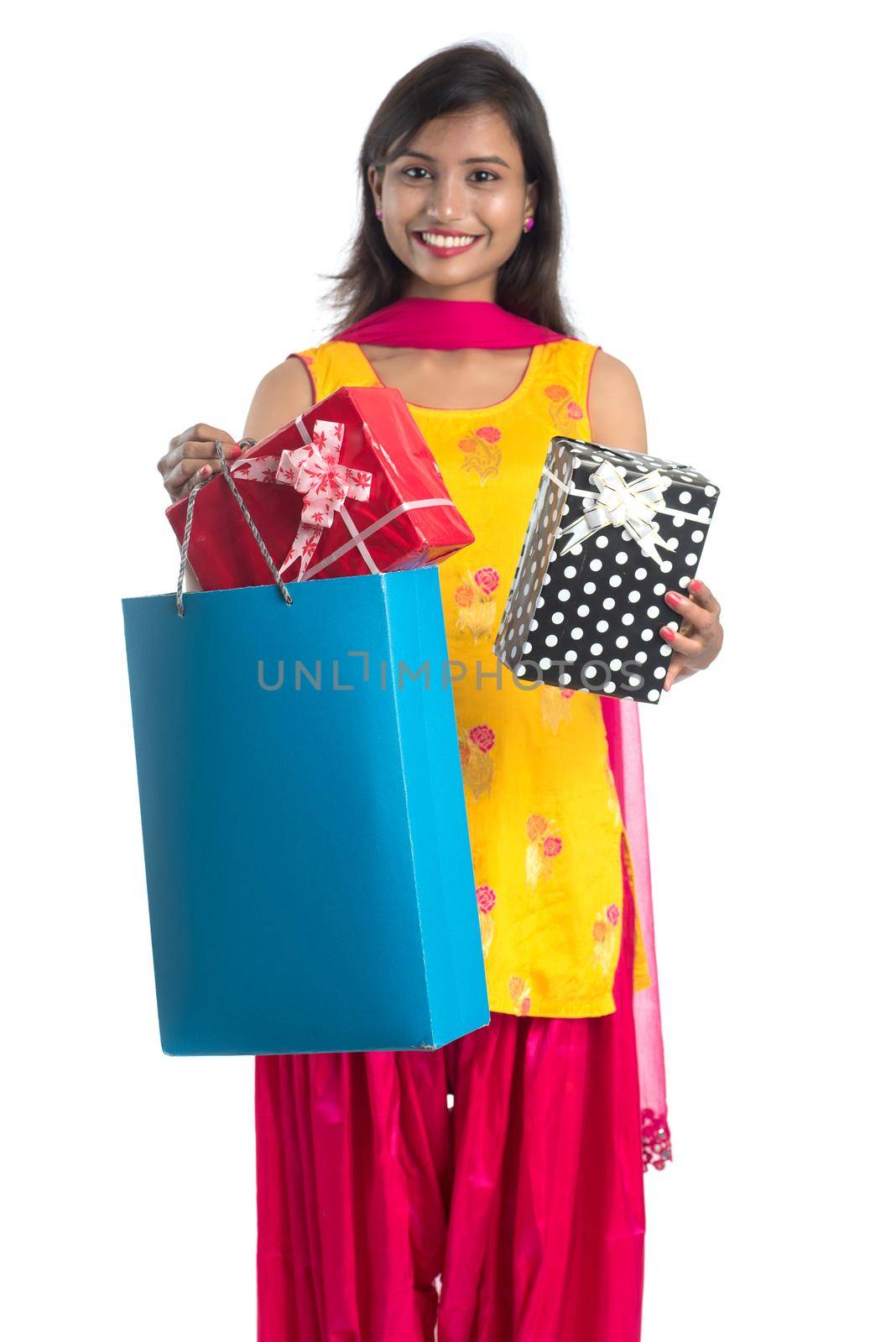 A beautiful woman posing with a shopping bag and gift Boxes on a white background.