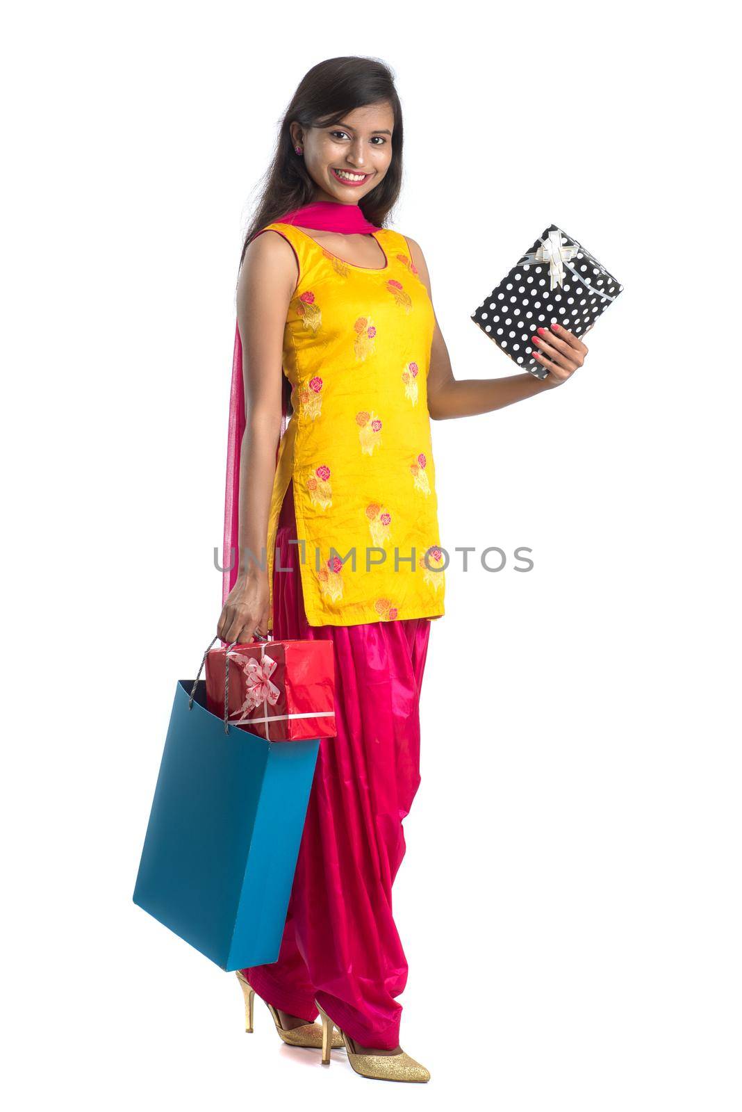 A beautiful woman posing with a shopping bag and gift Boxes on a white background.