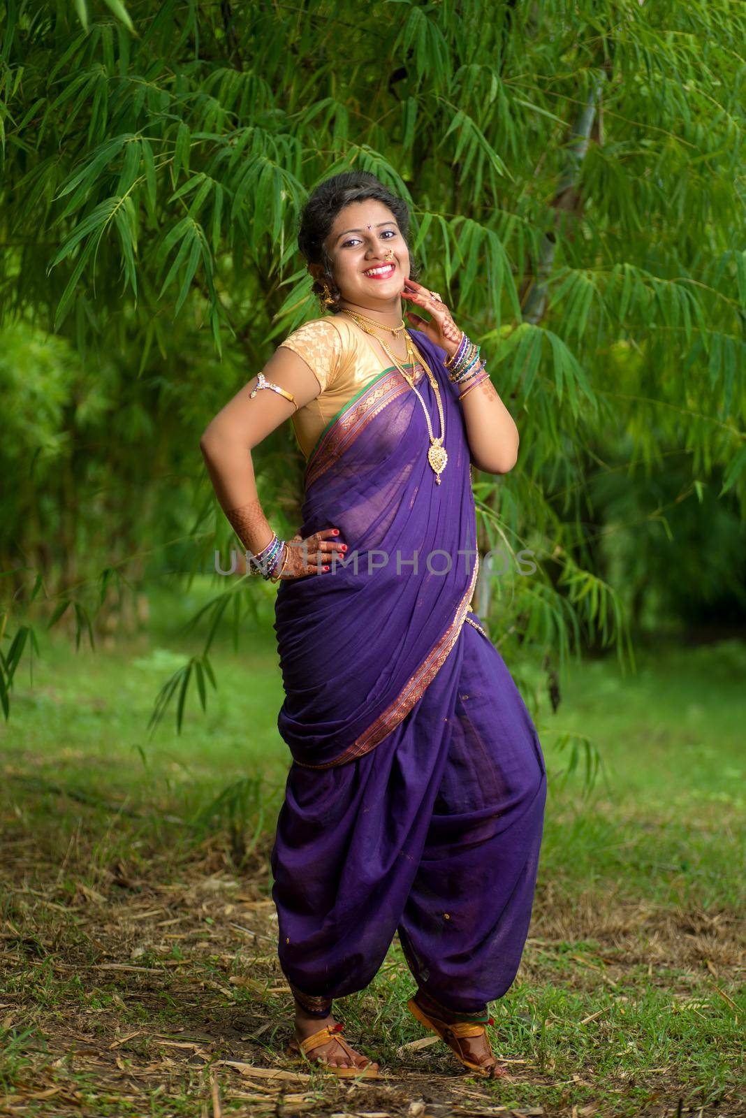 Indian Beautiful young girl in Traditional Saree posing outdoors