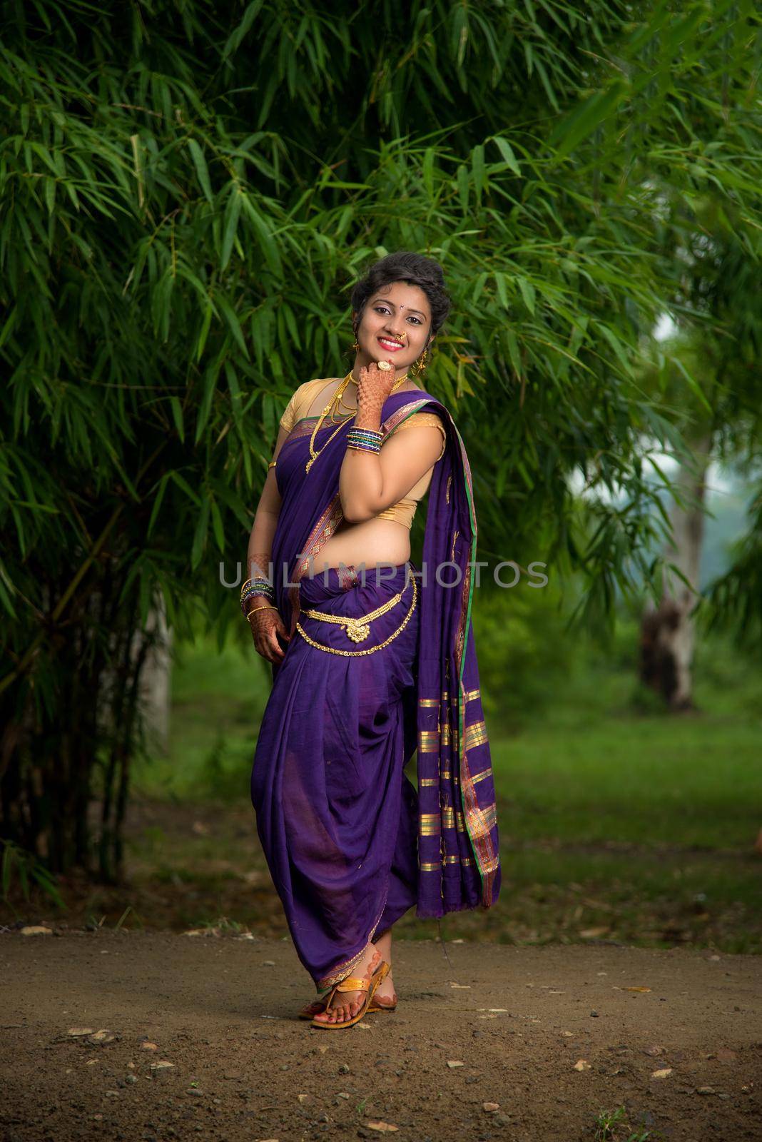 Indian Beautiful young girl in Traditional Saree posing outdoors