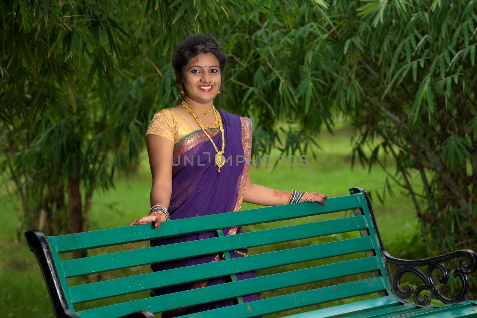 Beautiful Indian young girl in Traditional Saree posing outdoors