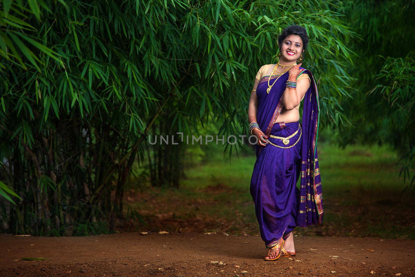 Indian Beautiful young girl in Traditional Saree posing outdoors