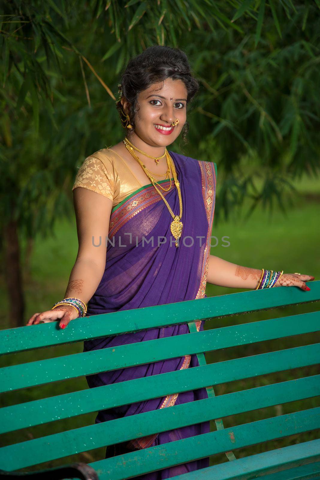 Beautiful Indian young girl in Traditional Saree posing outdoors