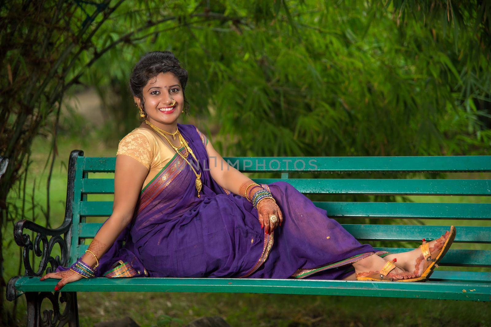 Beautiful Indian young girl in Traditional Saree posing outdoors