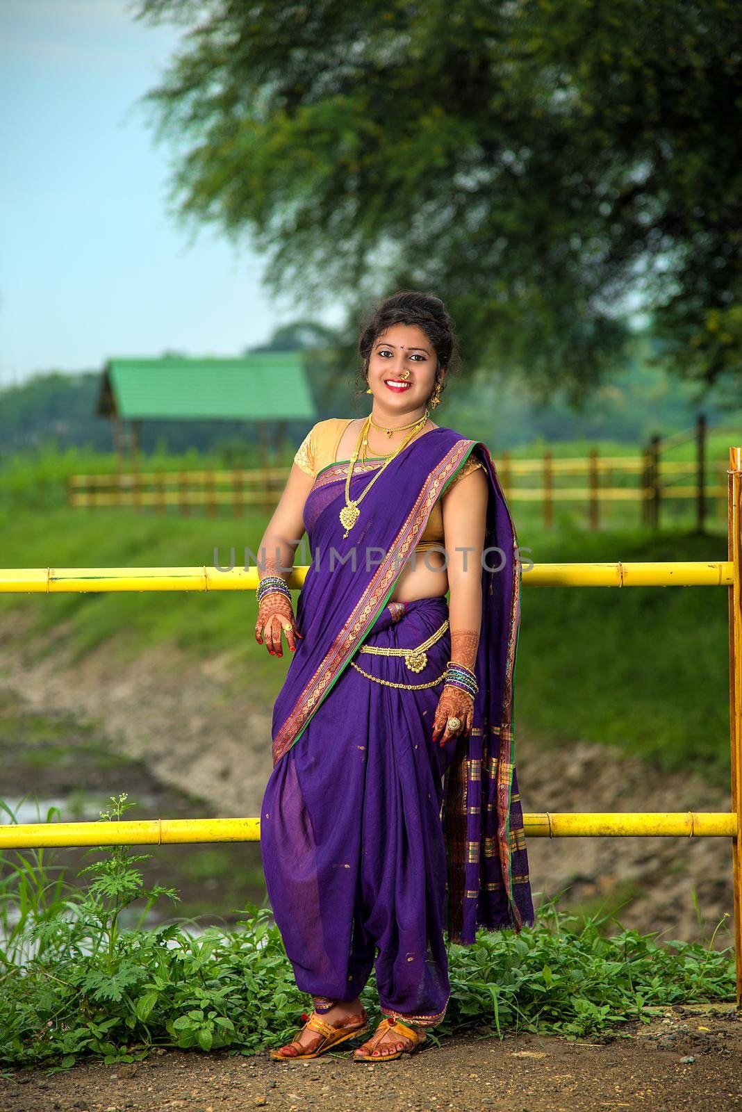 Beautiful Indian young girl in Traditional Saree posing outdoors