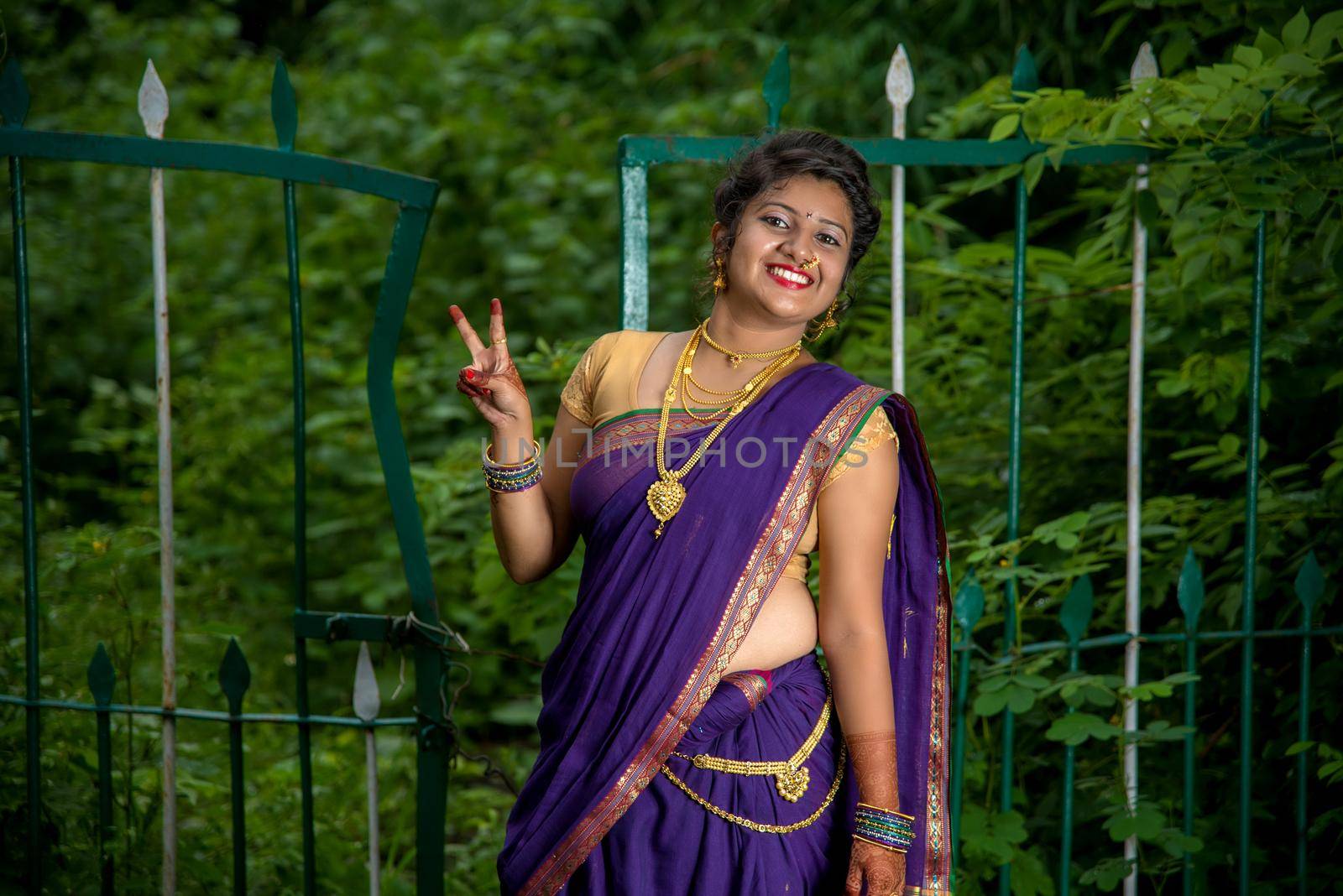 Beautiful Indian young girl in Traditional Saree posing outdoors