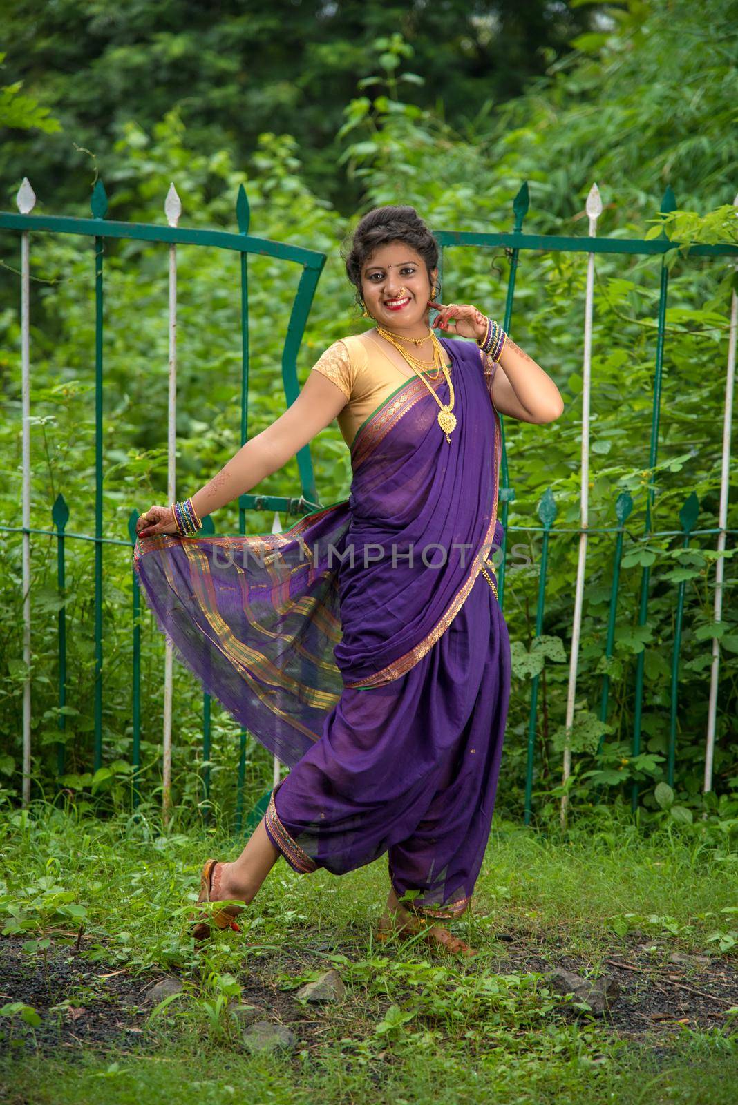 Beautiful Indian young girl in Traditional Saree posing outdoors