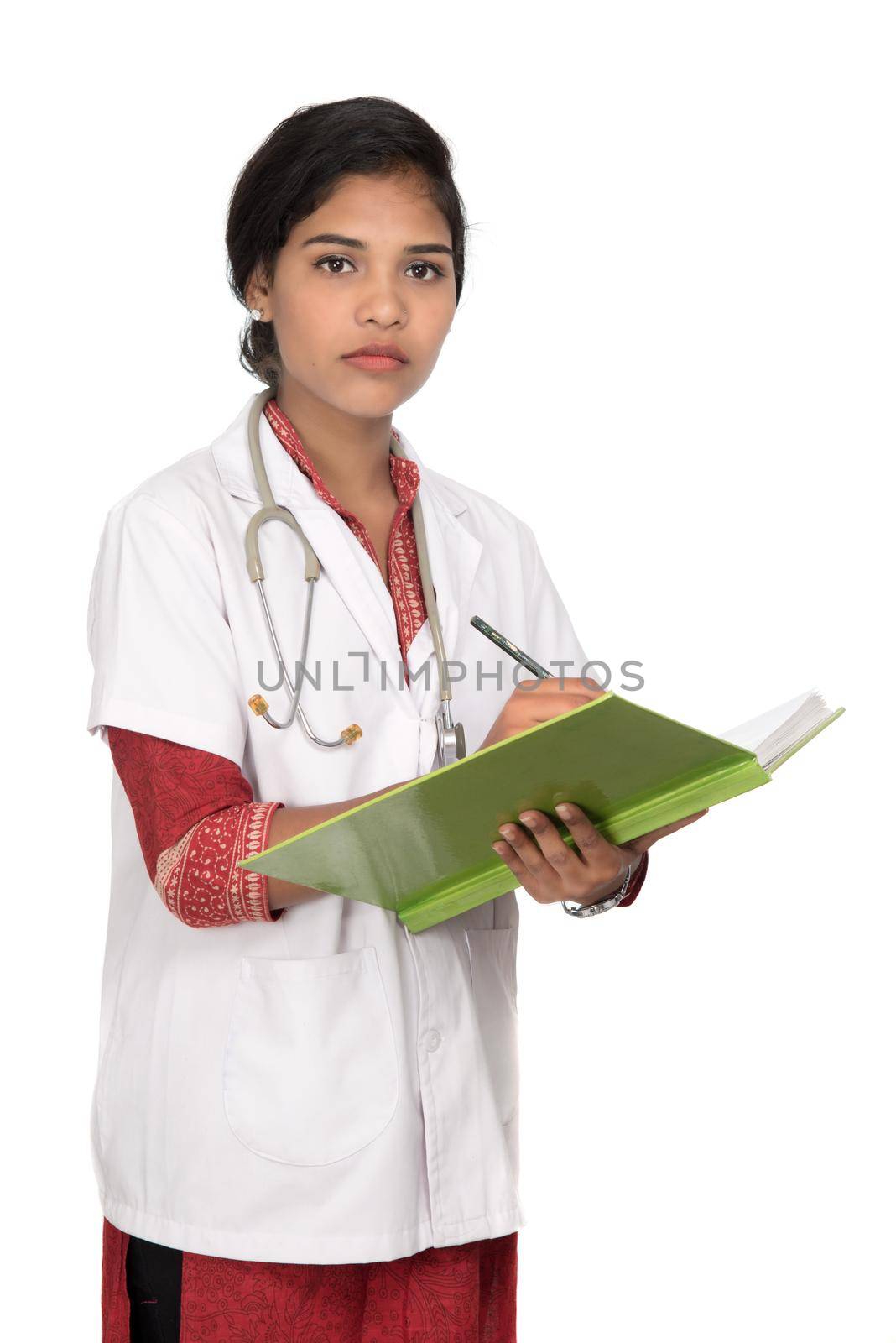 Young woman doctor with stethoscope is writing in book by DipakShelare
