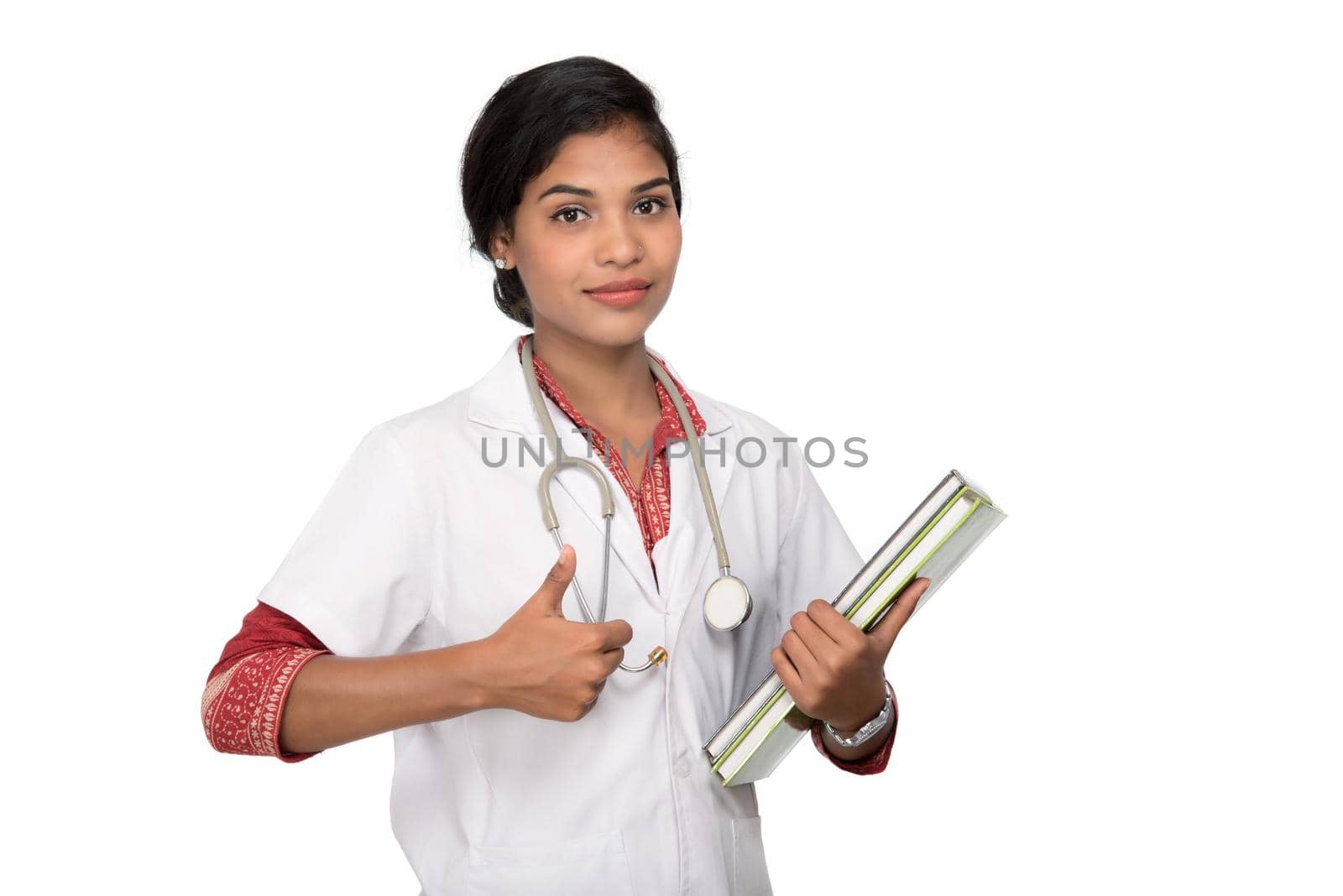 Young woman doctor holding book with stethoscope by DipakShelare