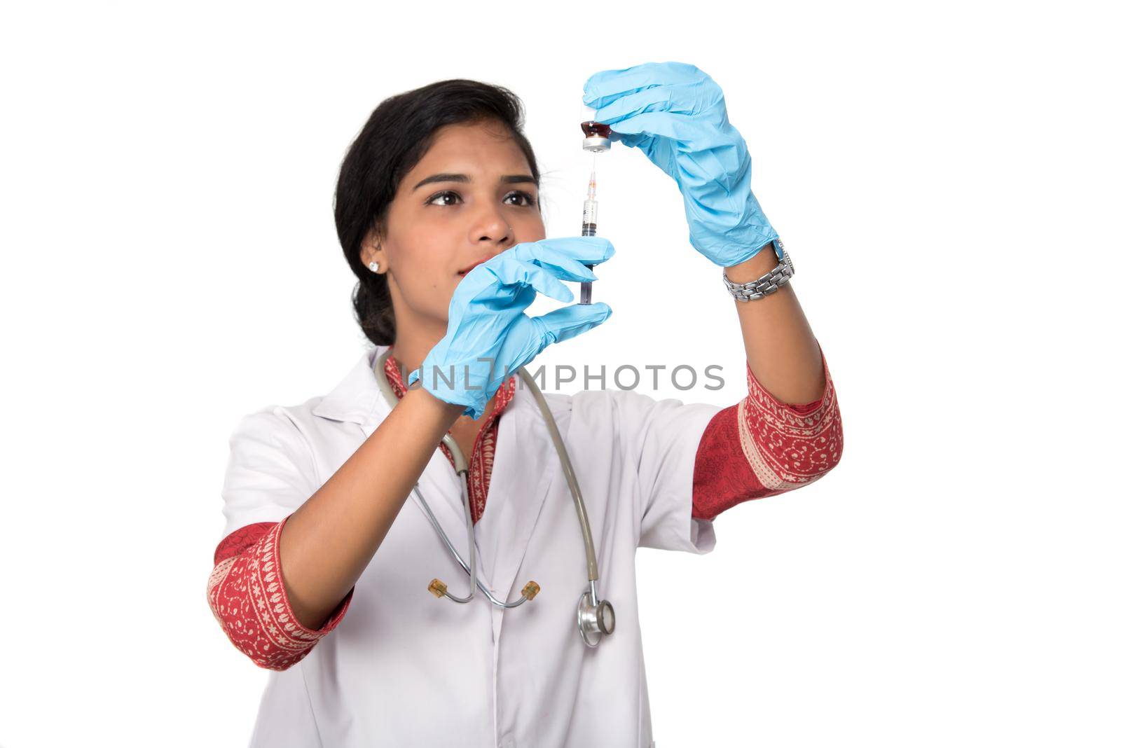 A female doctor with a stethoscope is holding an Injection or Syringe. by DipakShelare