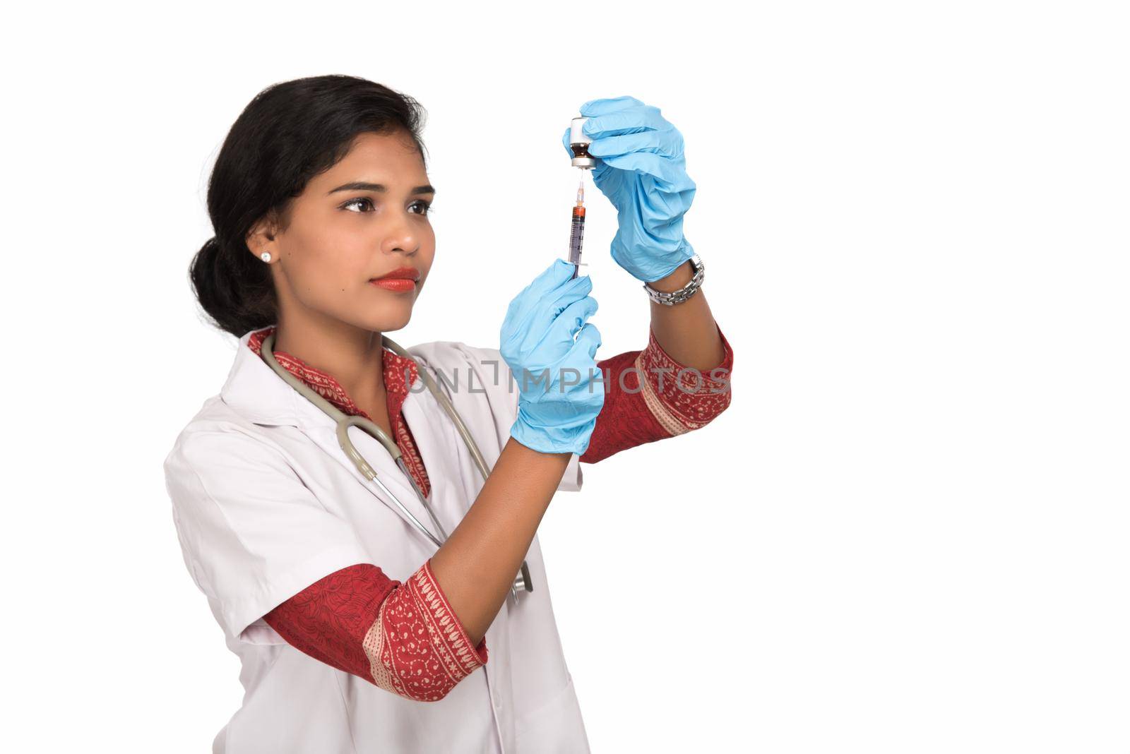 A female doctor with a stethoscope is holding an Injection or Syringe. by DipakShelare