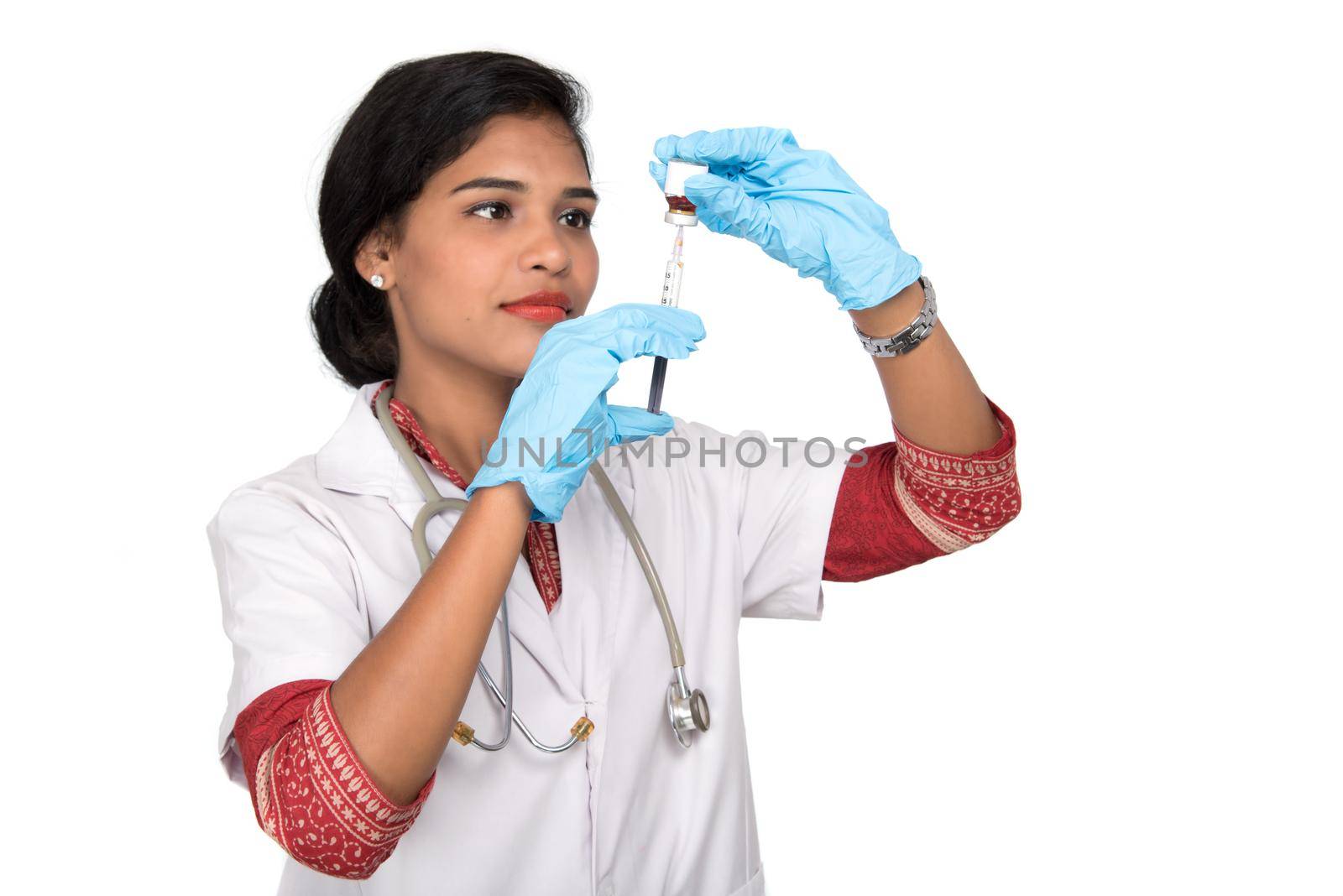 A female doctor with a stethoscope is holding an Injection or Syringe. by DipakShelare