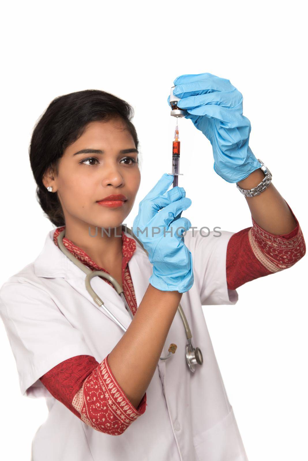 A female doctor with a stethoscope is holding an Injection or Syringe. by DipakShelare