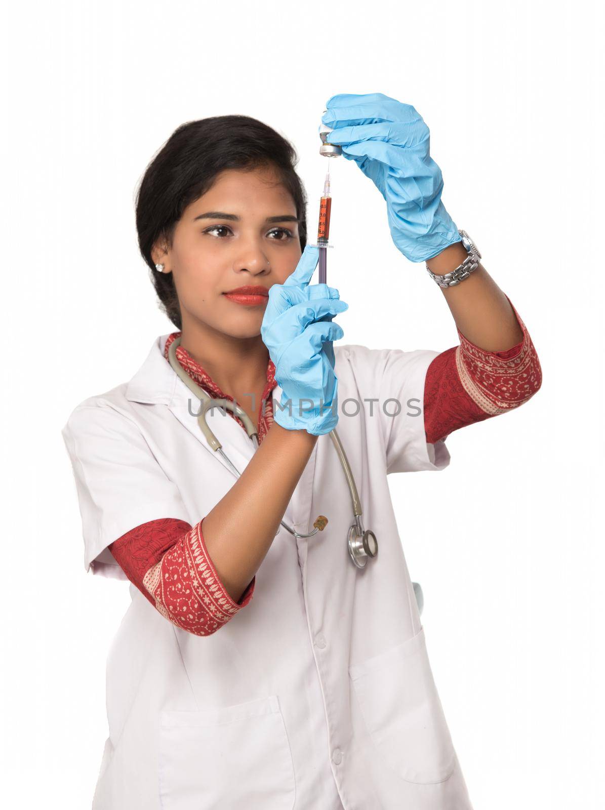 A female doctor with a stethoscope is holding an Injection or Syringe. by DipakShelare