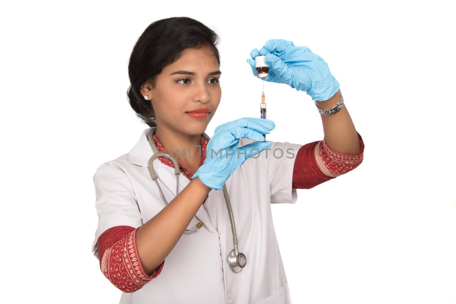 A female doctor with a stethoscope is holding an Injection or Syringe. by DipakShelare