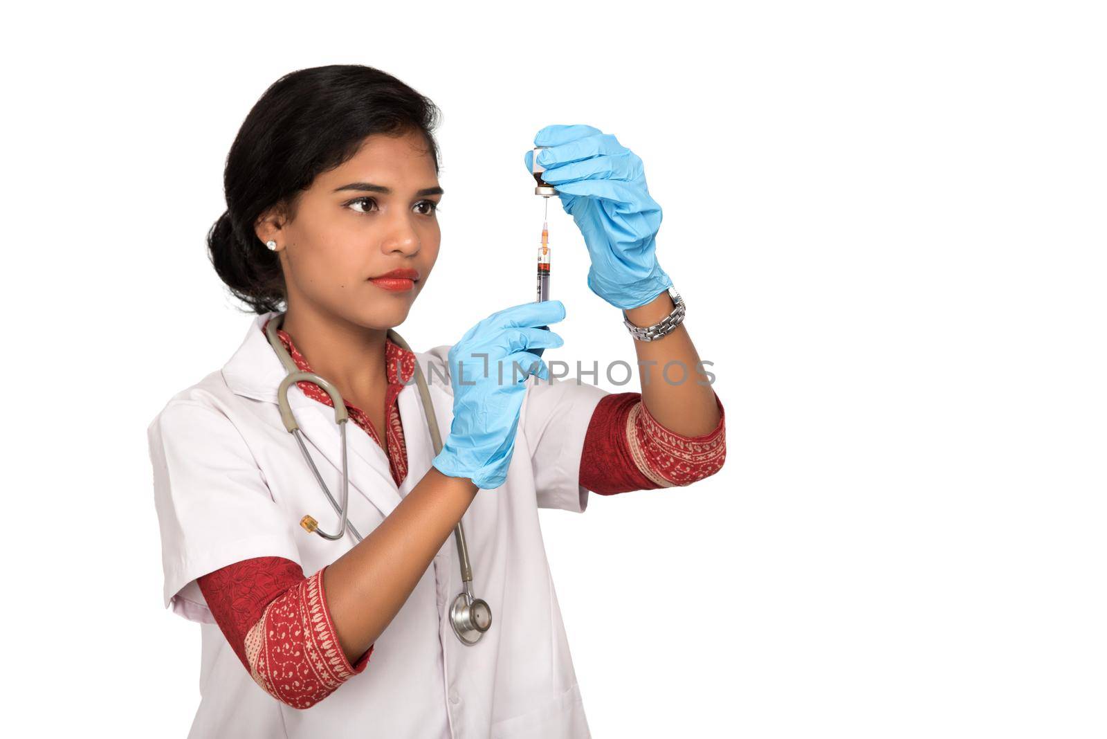 A female doctor with a stethoscope is holding an Injection or Syringe. by DipakShelare