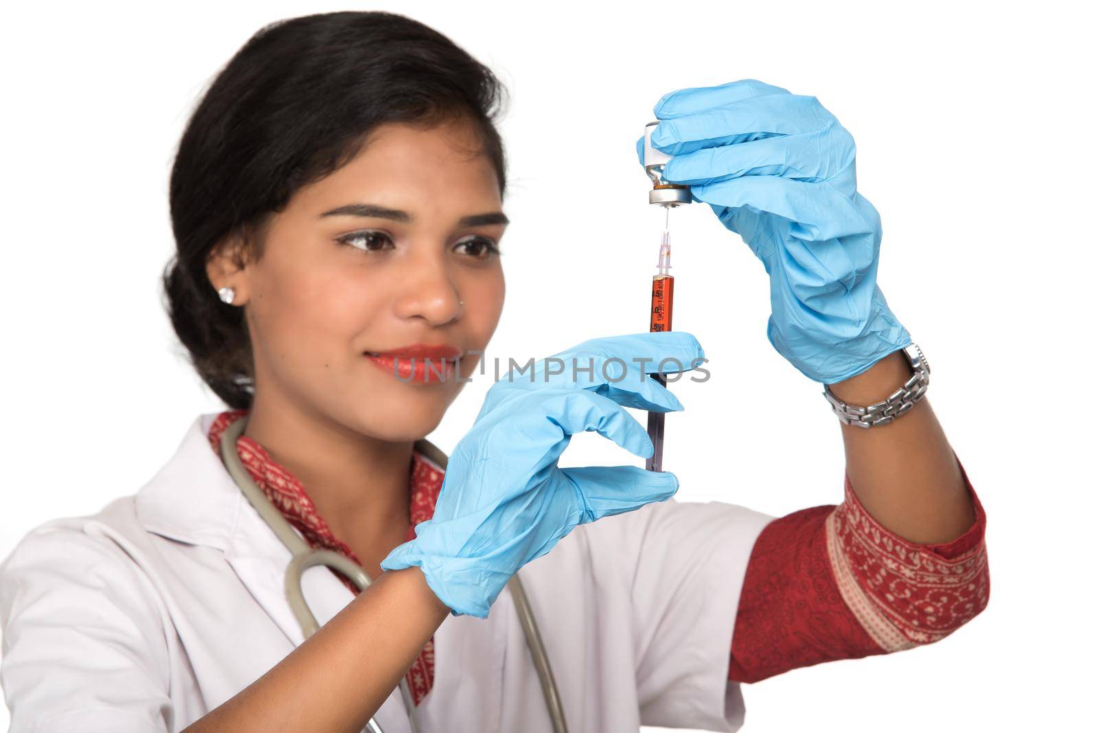 A female doctor with a stethoscope is holding an Injection or Syringe.