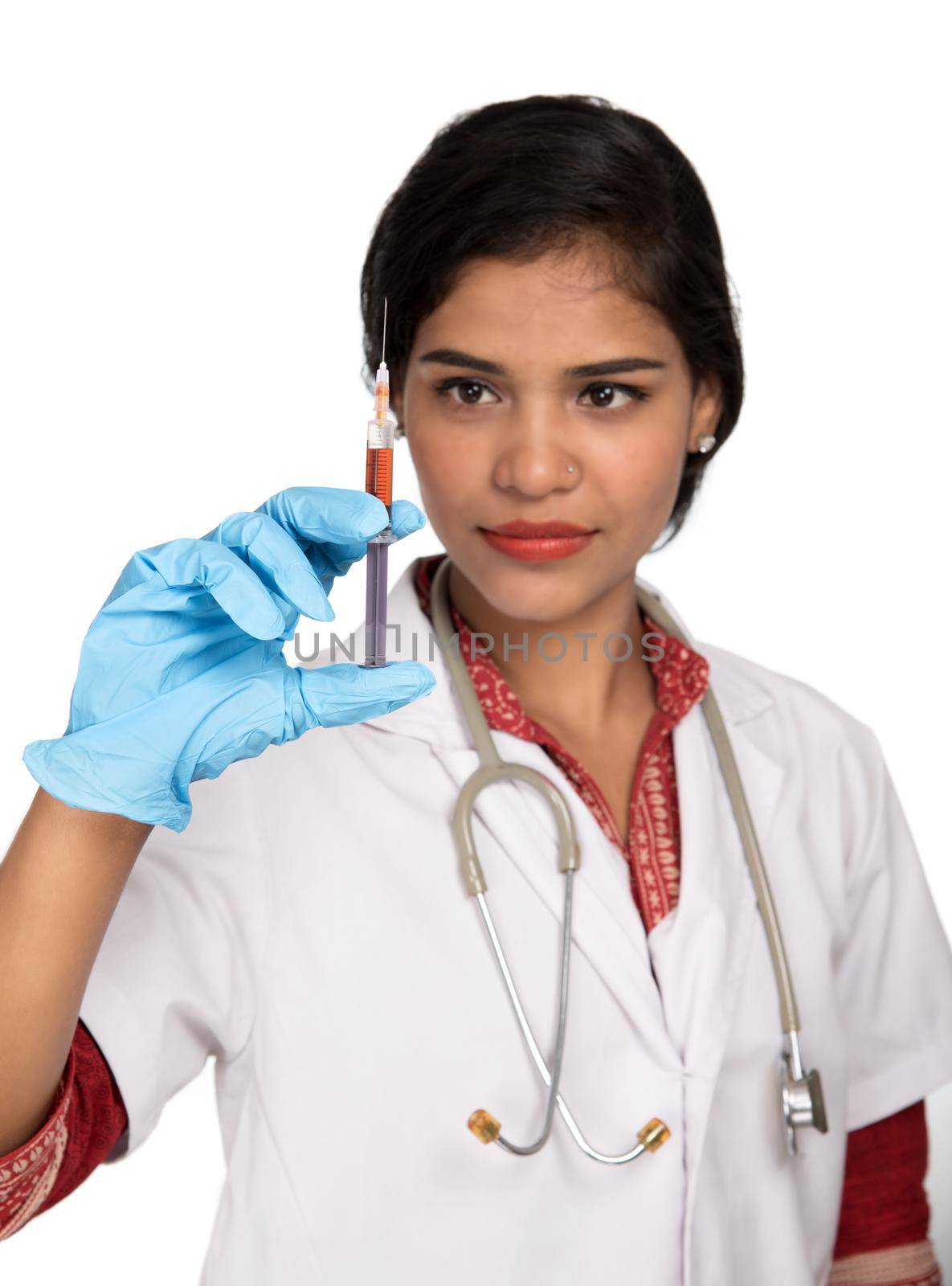 A female doctor with a stethoscope is holding an Injection or Syringe.