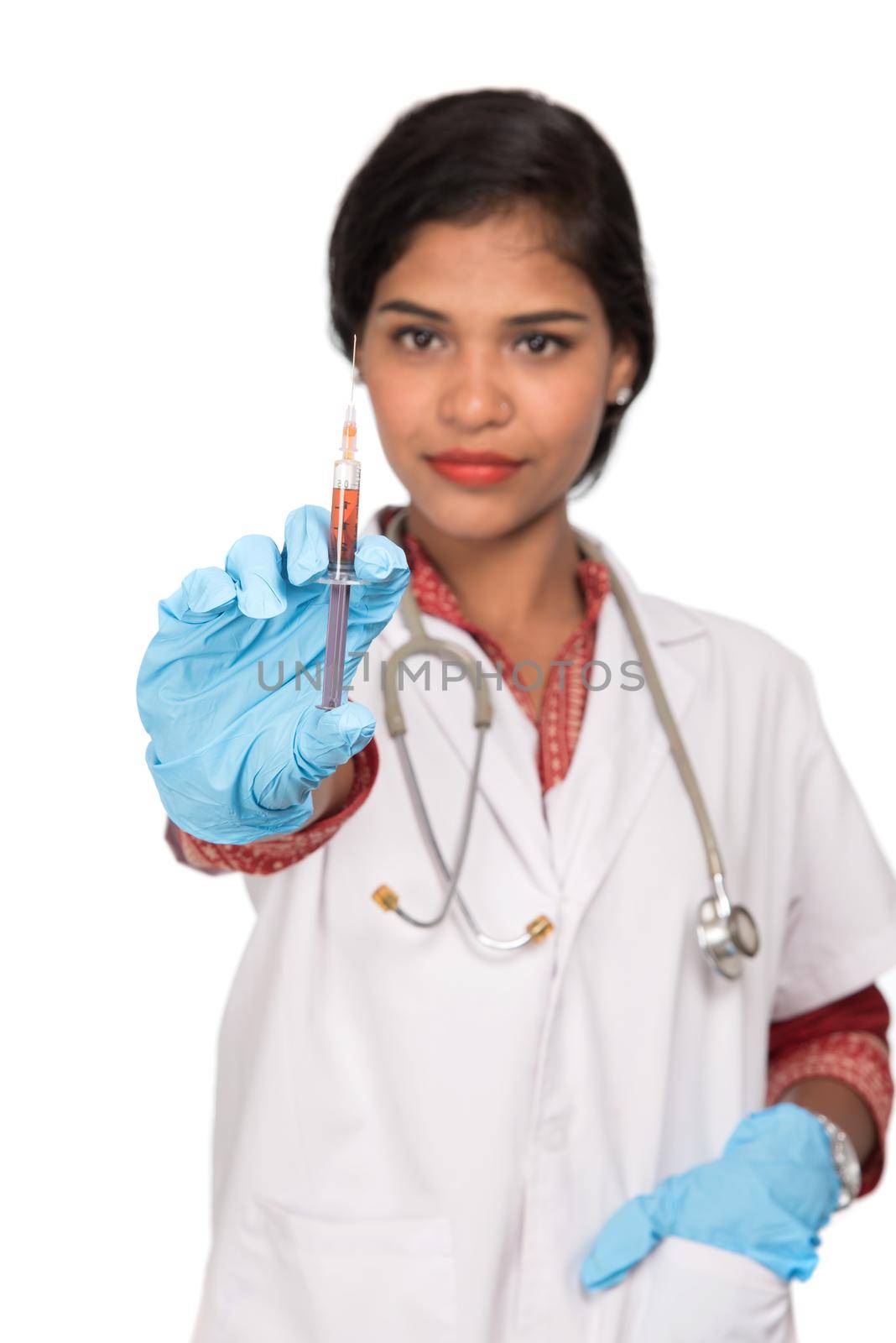 A female doctor with a stethoscope is holding an Injection or Syringe.