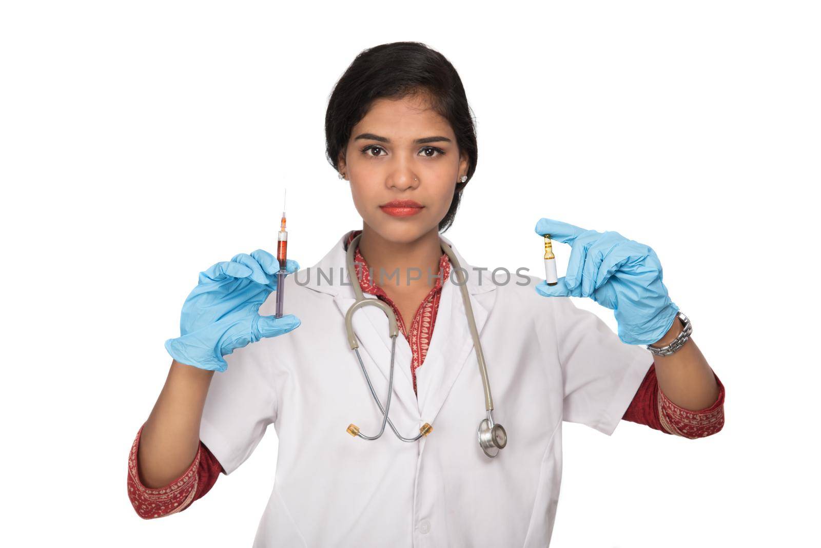 A female doctor with a stethoscope is holding an Injection or Syringe.