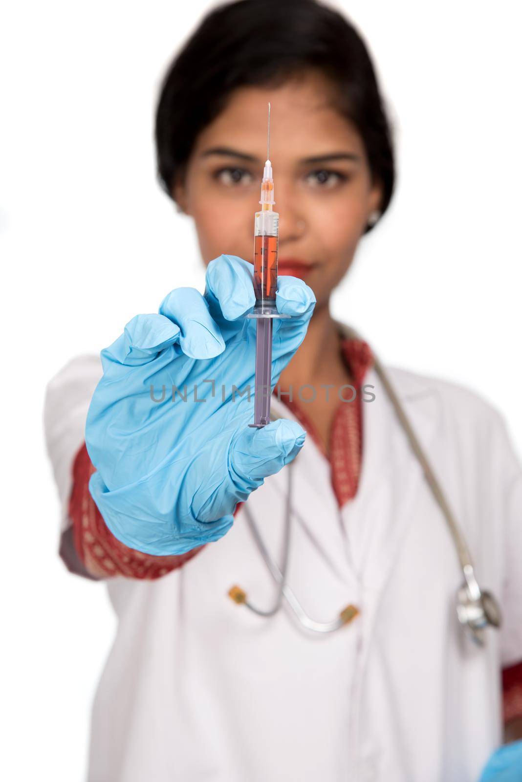 A female doctor with a stethoscope is holding an Injection or Syringe.