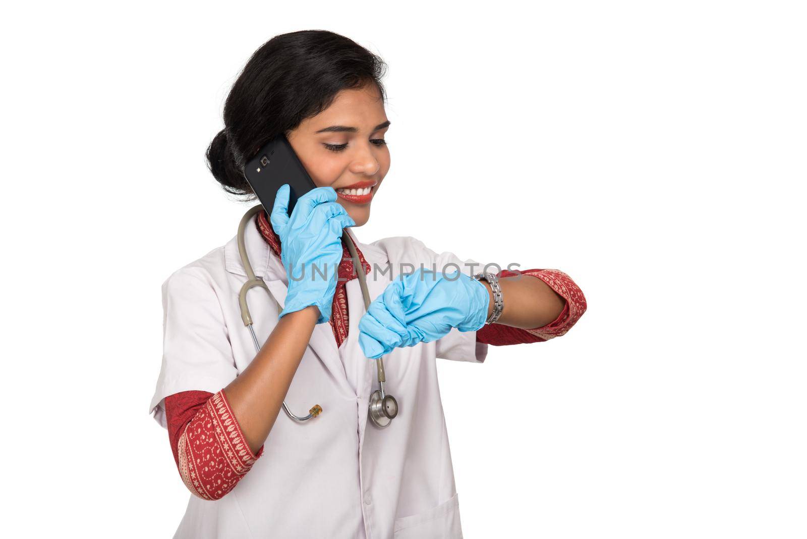 Female doctor with stethoscope talking on mobile phone on white background