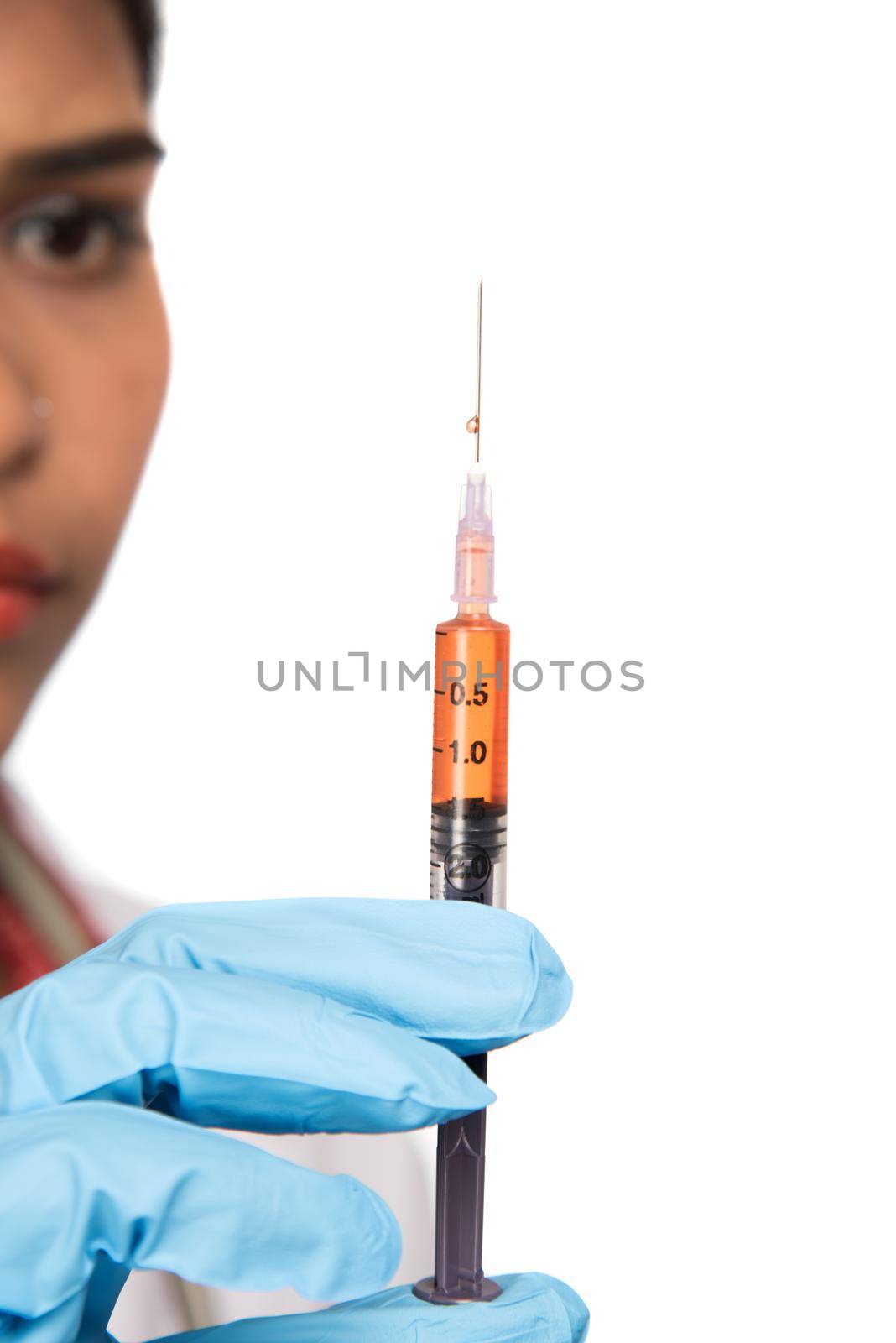 A female doctor with a stethoscope is holding an Injection or Syringe.