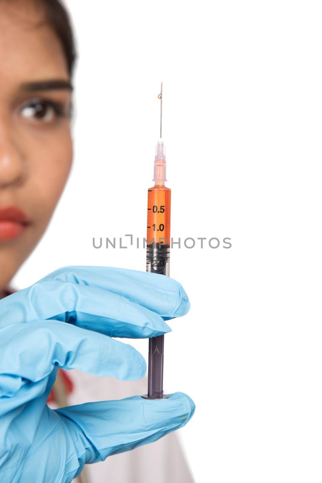 A female doctor with a stethoscope is holding an Injection or Syringe.