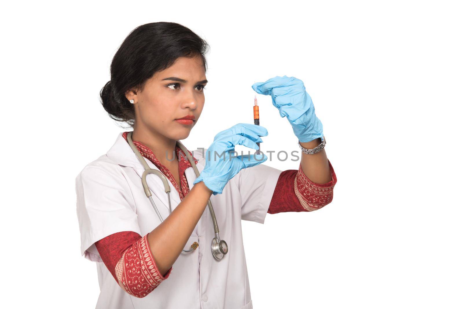 A female doctor with a stethoscope is holding an Injection or Syringe.
