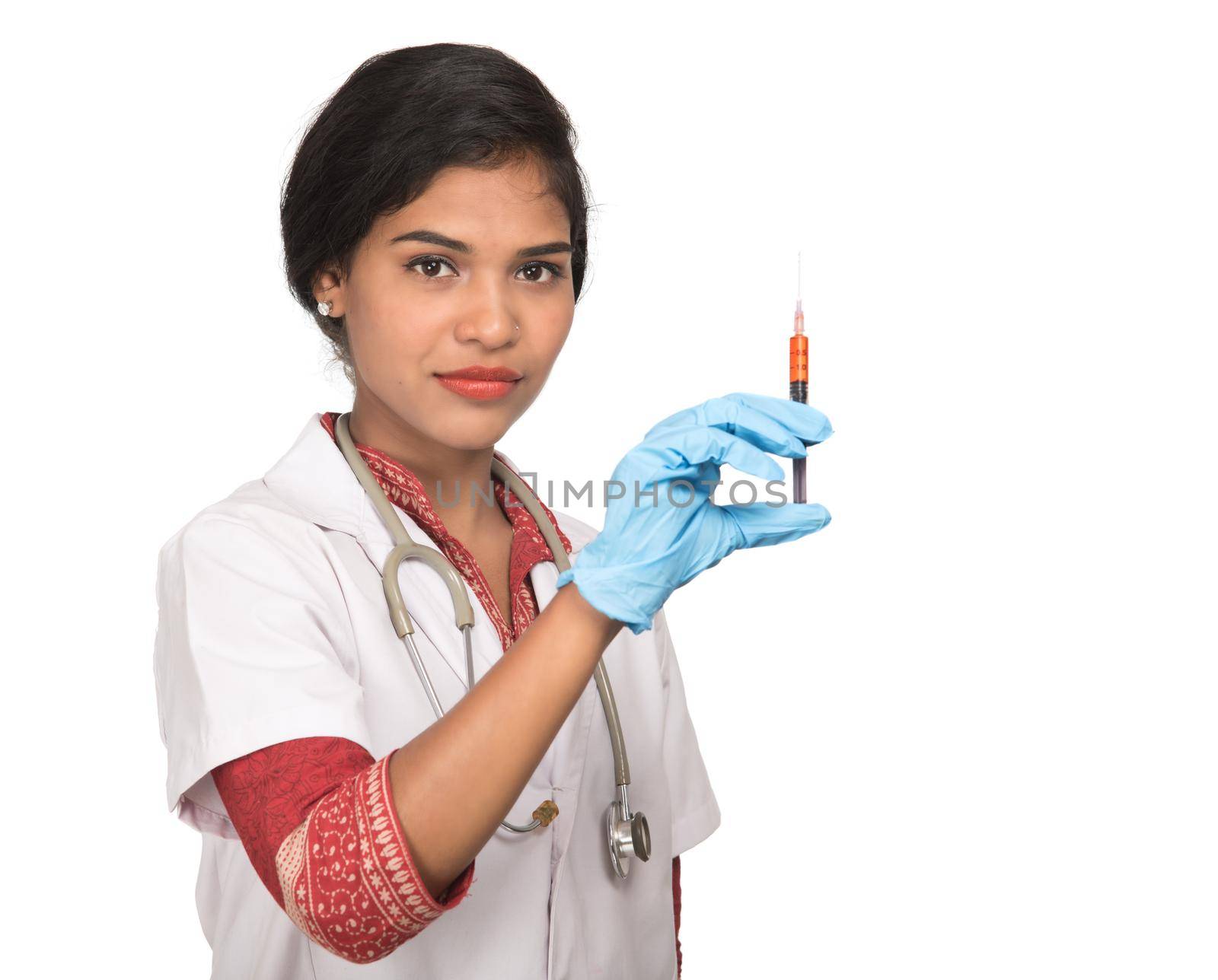 A female doctor with a stethoscope is holding an Injection or Syringe.