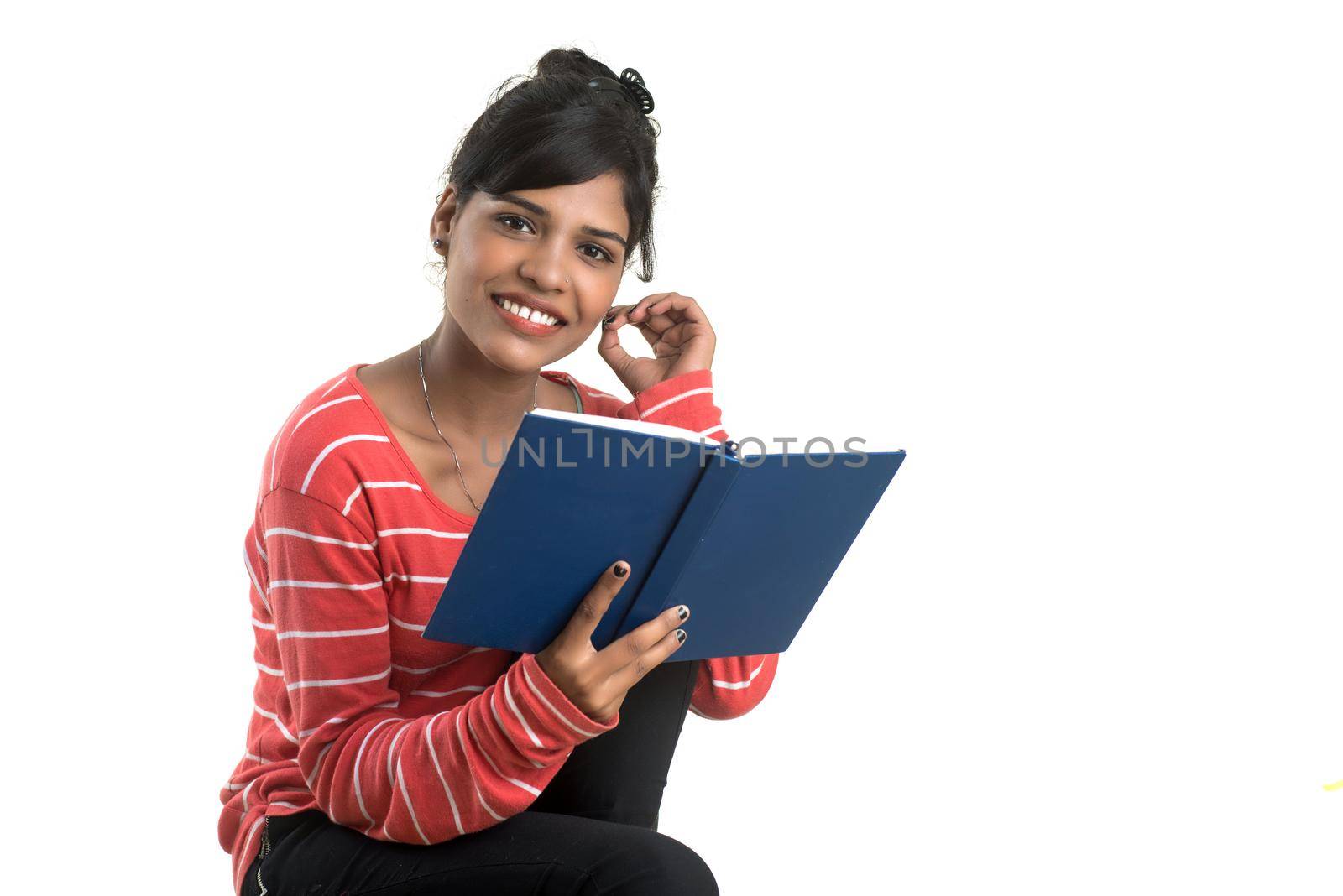 Pretty young girl holding book and posing on white background by DipakShelare