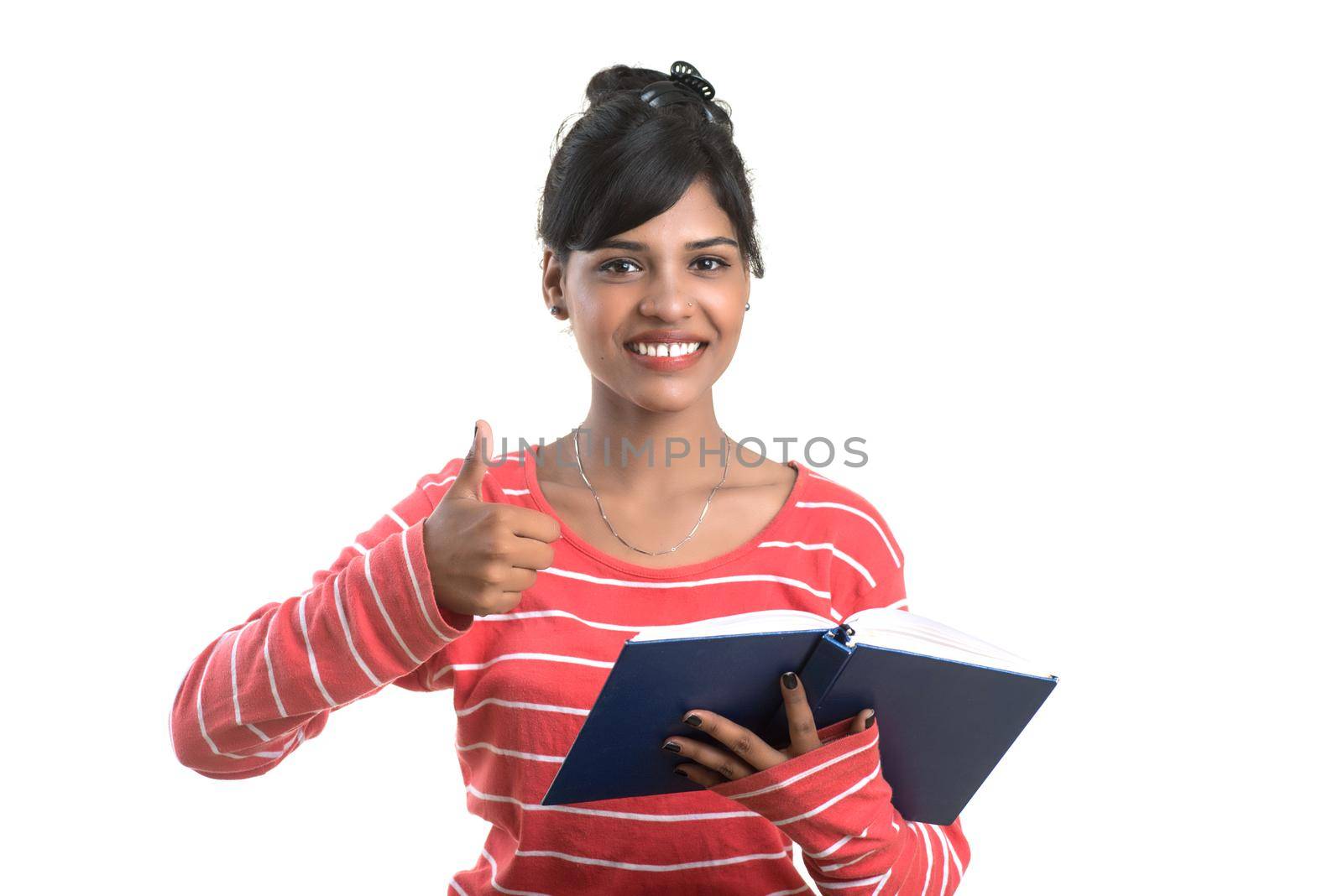 Pretty young girl holding book and posing on white background