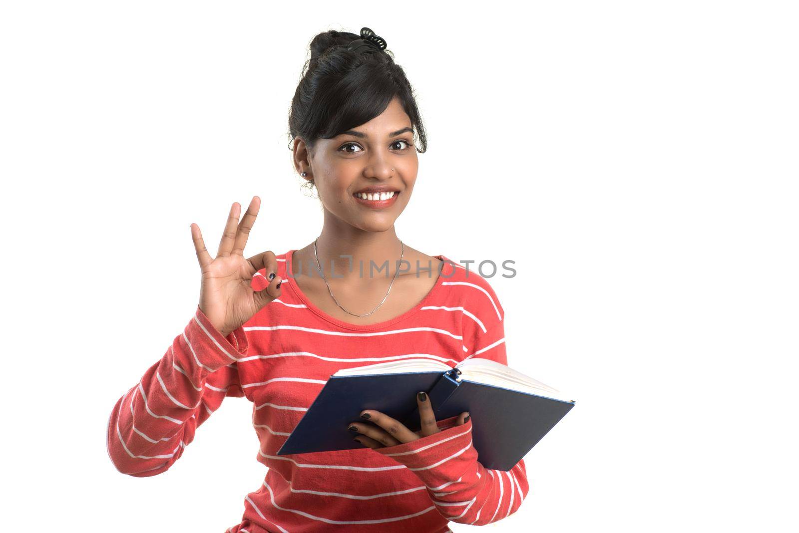 Pretty young girl holding book and posing on white background