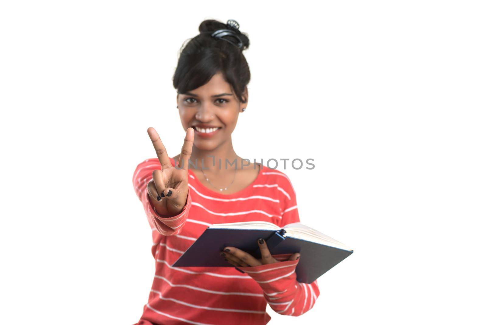 Pretty young girl holding book and posing on white background