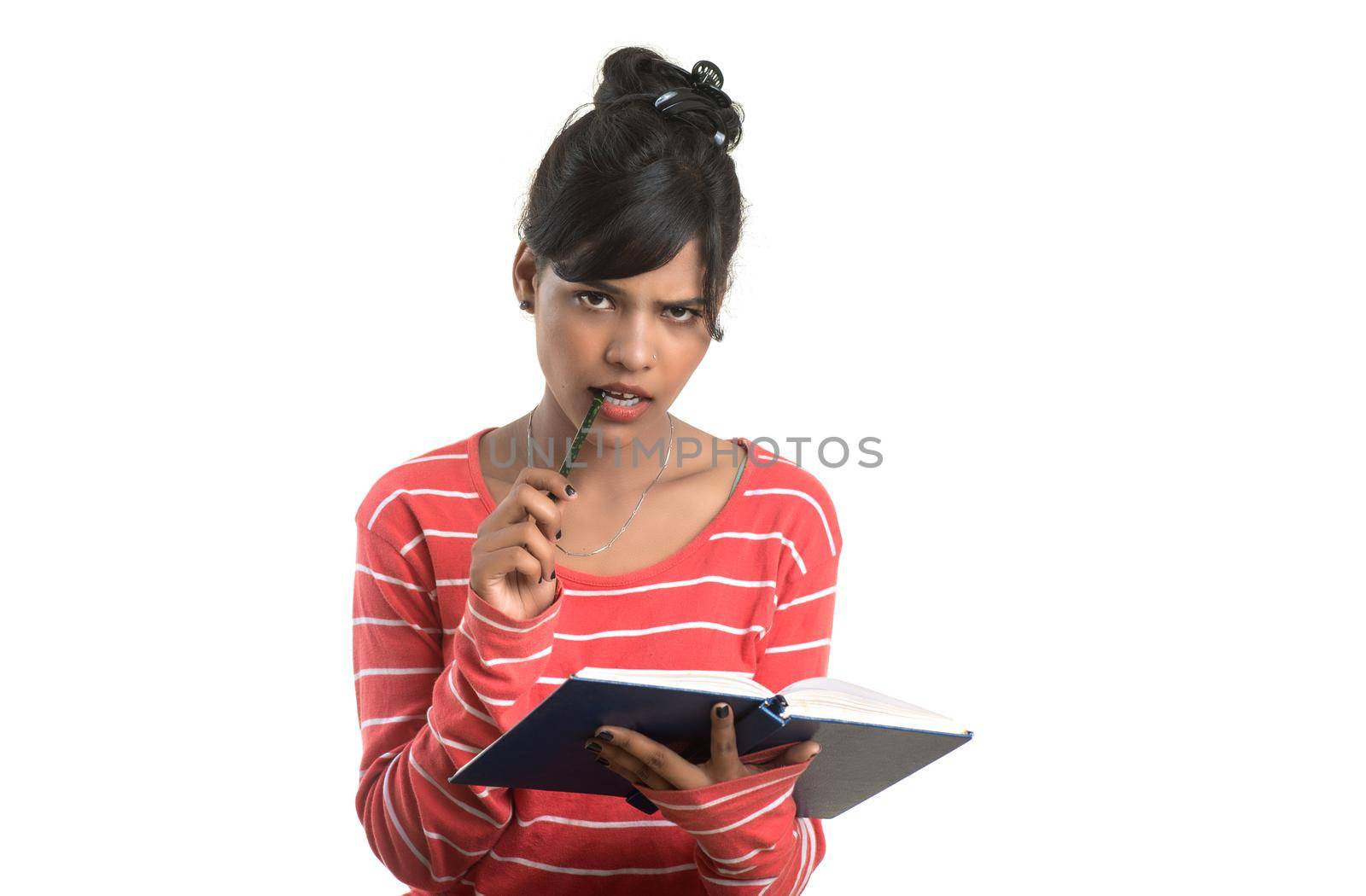 Pretty young girl holding book and posing on white background