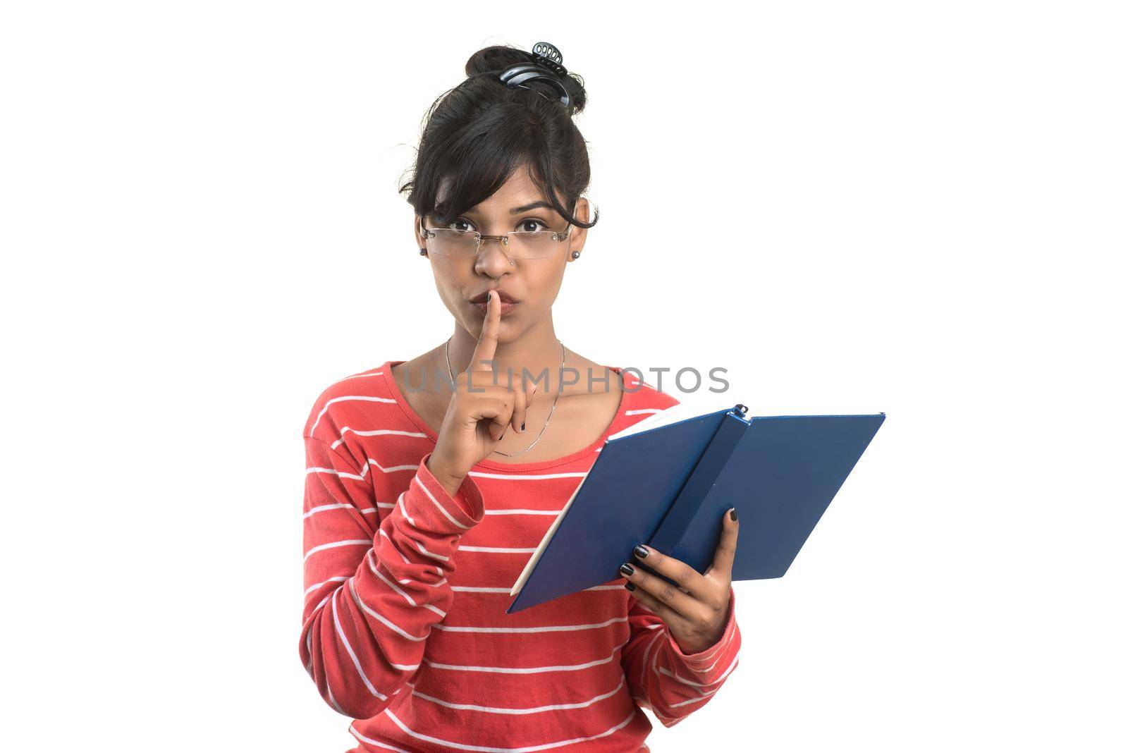 Pretty young girl holding book and posing on white background