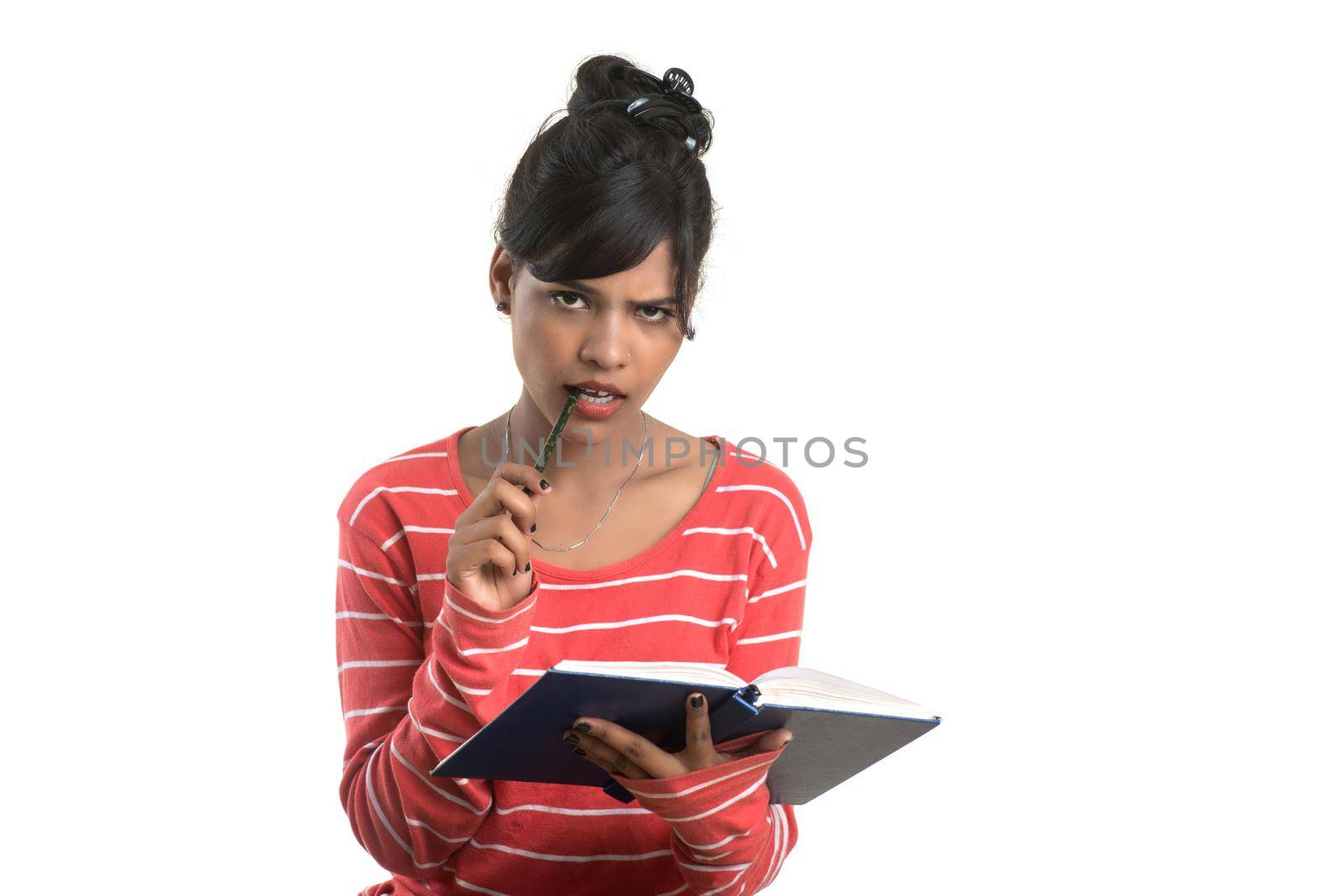 Pretty young girl holding book and posing on white background