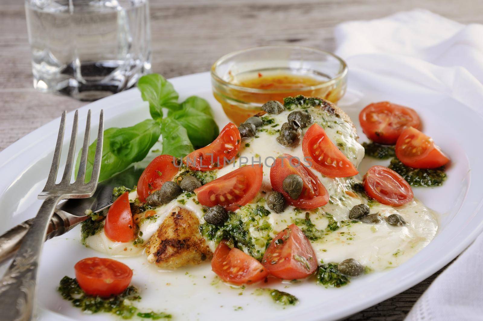 grilled chicken breast  topped with melted mozzarella cheese, basil  pesto, tomato  and caper