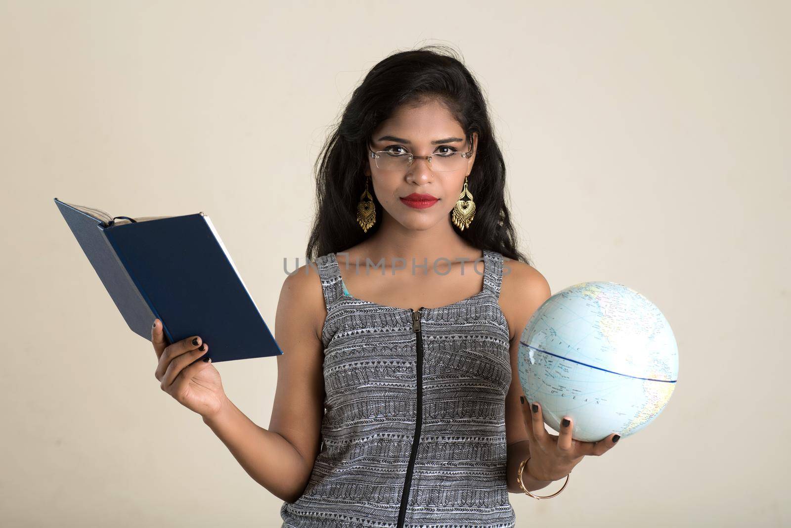 Young girl student holding book with globe on white background. Education in high school university college concept by DipakShelare